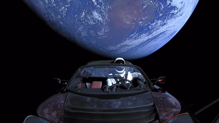 Space car Tesla Roadster, Erde im Hintergrund